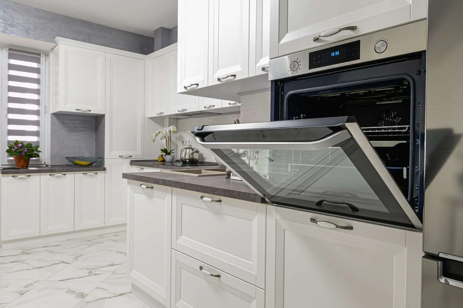 White kitchen with a built in oven standing open